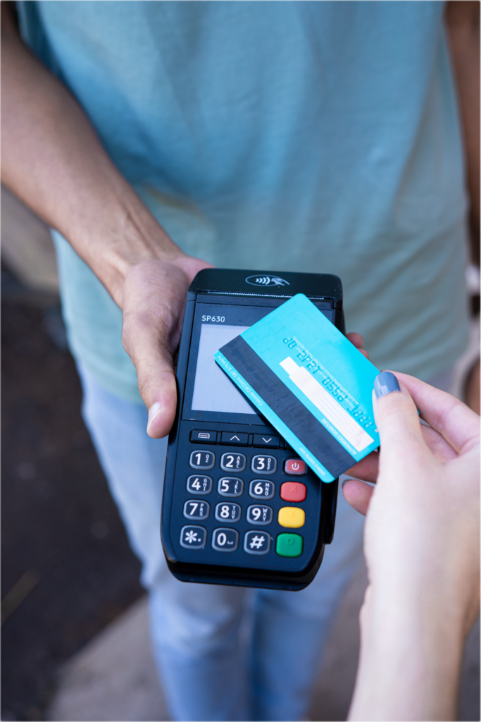 Close-up of hands performing contactless payment with credit card in Durban, South Africa.